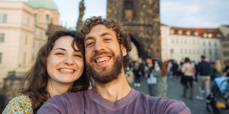 Et par tar en selfie på Karlsbroen i Praha i Tsjekkia og fanger romantikken i en av Europas mest fortryllende storbyferier.