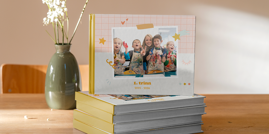 En fotoknudsen skolefotobok fra 2026 som viser smilende barn i kunsttime på skolen, som inspirasjon til skoleårbok, fotoalbum for skolebilder og ideer til skolefotobok.