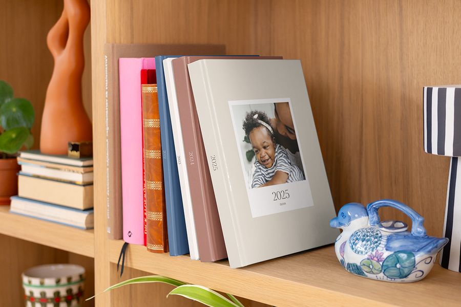 En rad med fargerike, mønstrede fotoknudsen årbøker pent utstilt i en bokhylle.