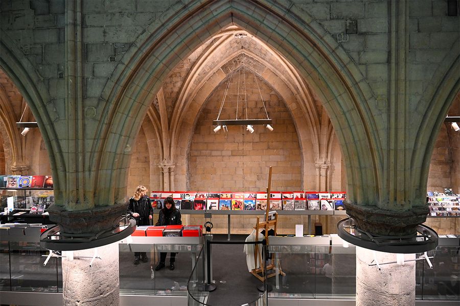 Boekhandel Dominicanen i Maastricht, en bokhandel i een 700 år gammel gotisk kirke med høye bokhyller og steinhvelv, en unik destinasjon for en litterær reise med fotoknudsen.