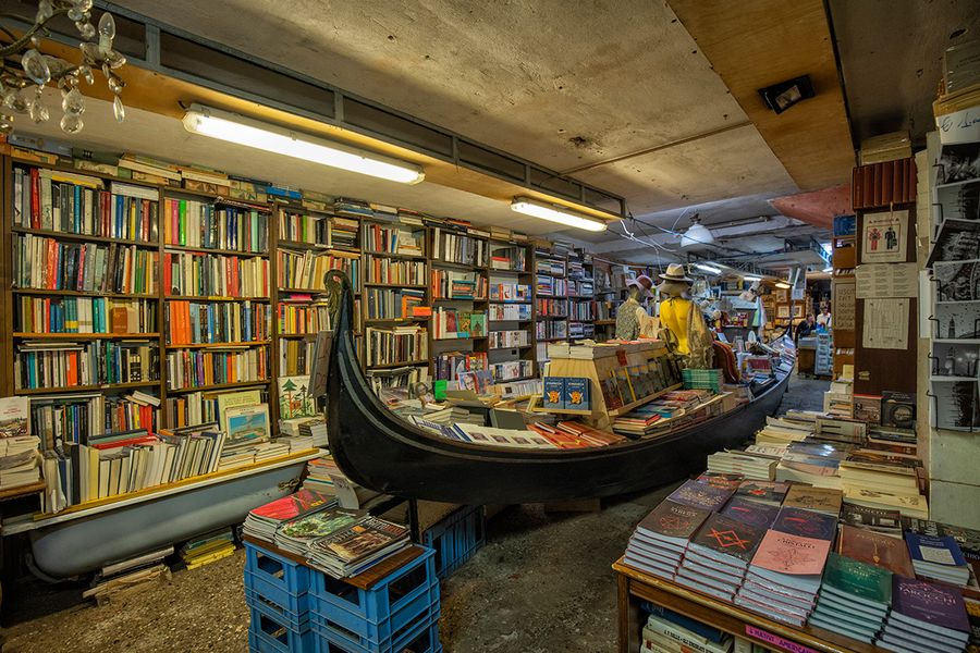 Libreria Acqua Alta i Venezia, Italia, hvor bøker oppbevares i en gondol og badekar for å beskytte mot vannet, en unik bokhandel for litterær reise med fotoknudsen.