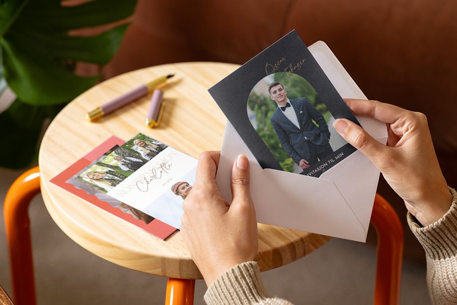 En person som ser på personlige konfirmasjonskort og invitasjoner til konfirmasjon 2026 hos fotoknudsen.