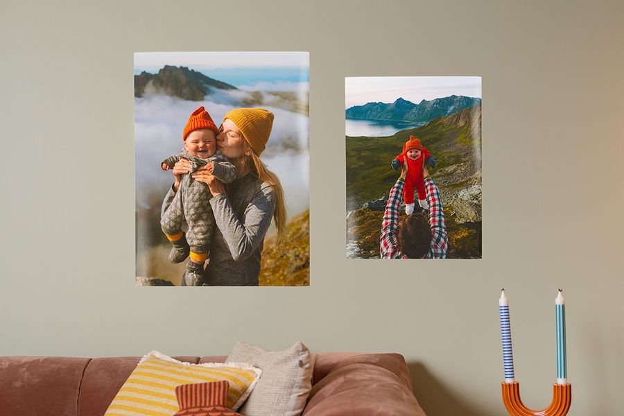 To familieplakater av mor og baby hengt opp over en sofa med bildeoppheng strips, en smart løsning for oppheng til bilder uten å lage hull hos fotoknudsen.