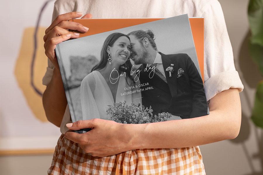 En kvinne holder en personlig fotoknudsen wedding coffee table photo book i hendene, som inspirasjon til en wedding coffee table book og en personlig coffee table photo book.