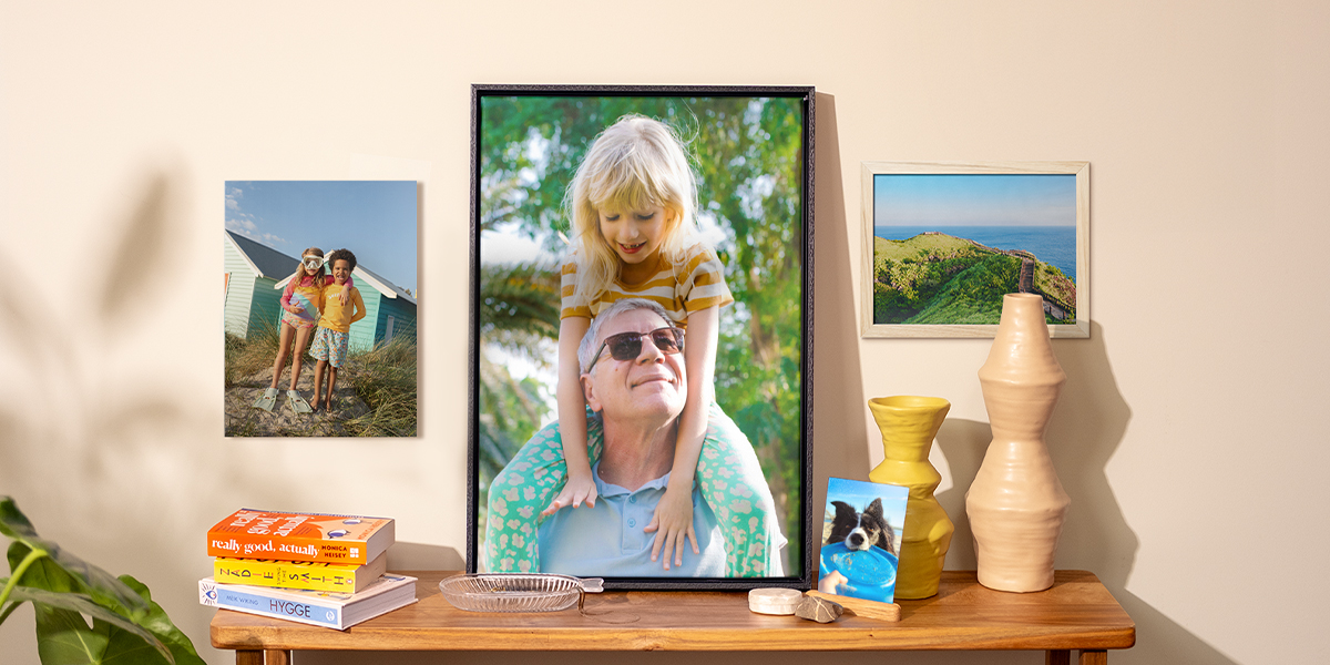 Et utvalg fotoknudsen bilder vist frem i hjemmet, med et hundebilde på et sidebord, en plakat av barn på veggen og to innrammede bilder, som inspirasjon til bilder på veggen og vårfrisk hjemmedekor.