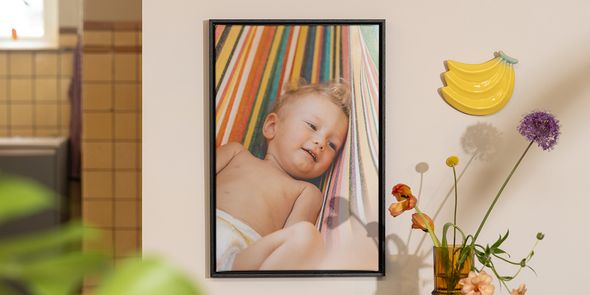 Personlig fotoknudsen veggdekor med et bilde av en baby ved siden av blomster og fruktdekor, som inspirasjon til å innrede sommerlig hjemme.