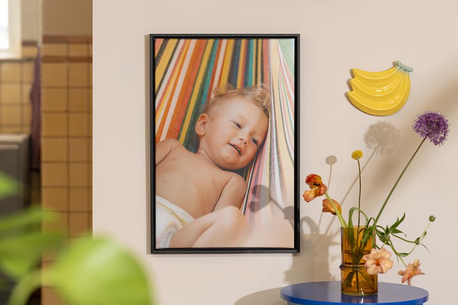 Personlig fotoknudsen veggdekor med et bilde av en baby ved siden av blomster og fruktdekor, som inspirasjon til å innrede sommerlig hjemme.