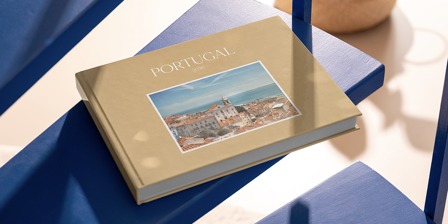 En personlig fotoknudsen familiefotobok merket Portugal 2026 ligger på et bord og bevarer minner fra familieferien som en fin måte å huske reisen på.