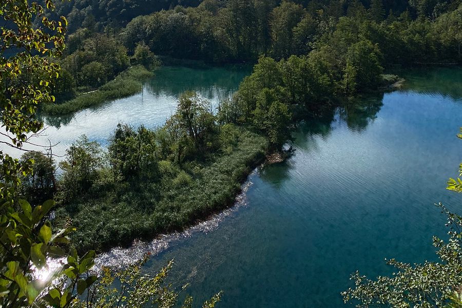 Fossefall i smaragdgrønt og trebroer over turkist vann ved Plitvicesjøene nasjonalpark i Kroatia, en av Europas vakreste nasjonalparker i fotoknudsen sin guide.