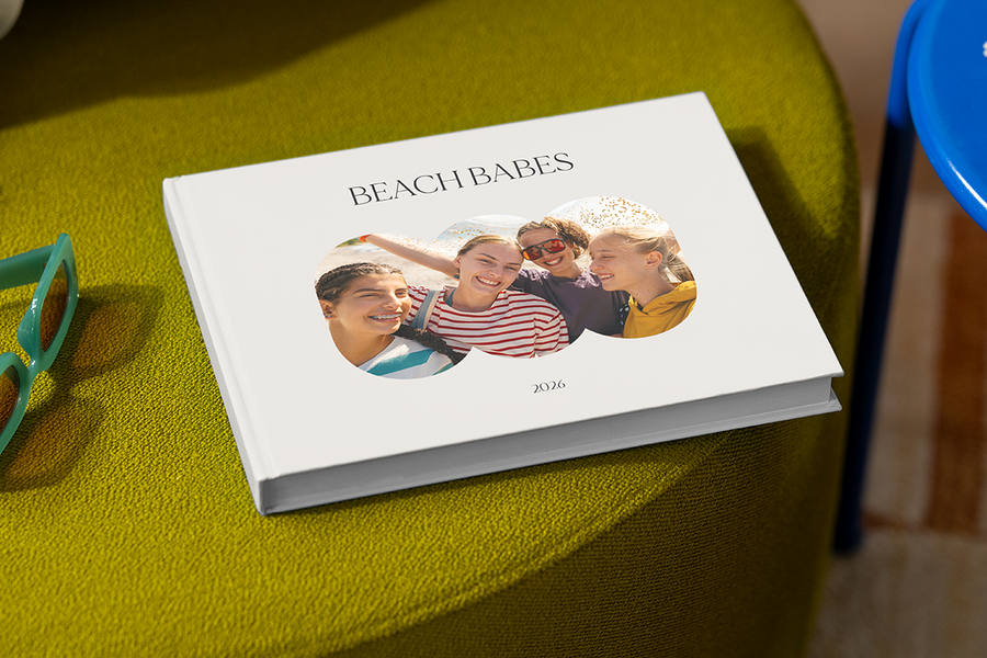 En fotobok med fire smilende jenter på forsiden heter 'Beach Babes', som illustrerer fotoknudsen sine fotobok tittel ideer for reiser med venner.
