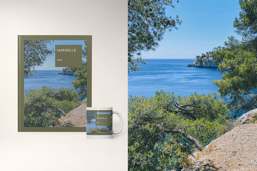 En fotobok og kopp i Travel Hues-designet fra fotoknudsen, med fargerike blokker inspirert av destinasjonspaletter, som Spanias varme terrakottatoner og Norges kjølige blåtoner.