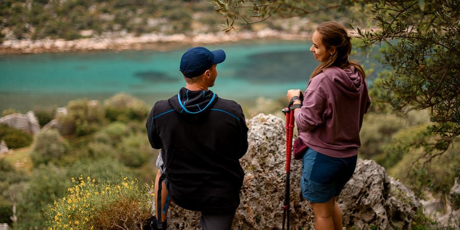 Et par står i en vakker nasjonalpark og ser ut over en blå sjø, som fanger den naturlige skjønnheten i fotoknudsen sin guide til de vakreste nasjonalparkene i Europa.