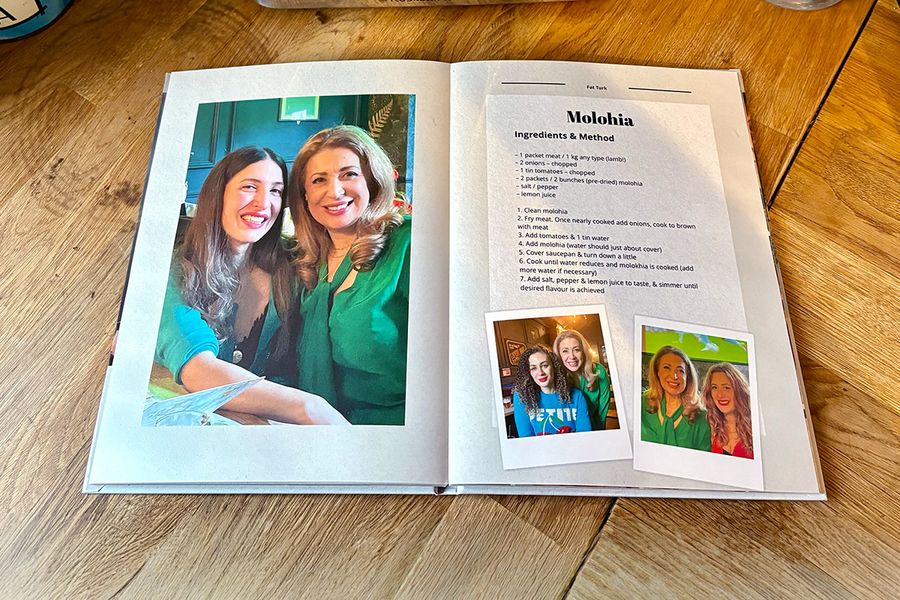 Et oppslag fra Sarahs personlige oppskriftsbok viser en oppskrift på molohia, ledsaget av familiebilder i stedet for et bilde av retten, som illustrerer fotoknudsen sitt tips om å inkludere personlige bilder som gjør en oppskriftsbok virkelig meningsfull.