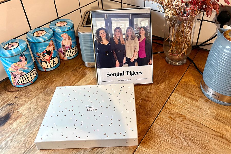 Sarahs personlige familieoppskriftsbok ligger i en fotoknudsen gaveboks, som illustrerer hvordan en personlig kokebok er en omtenksom gave til bursdager, jubileer og andre spesielle anledninger.