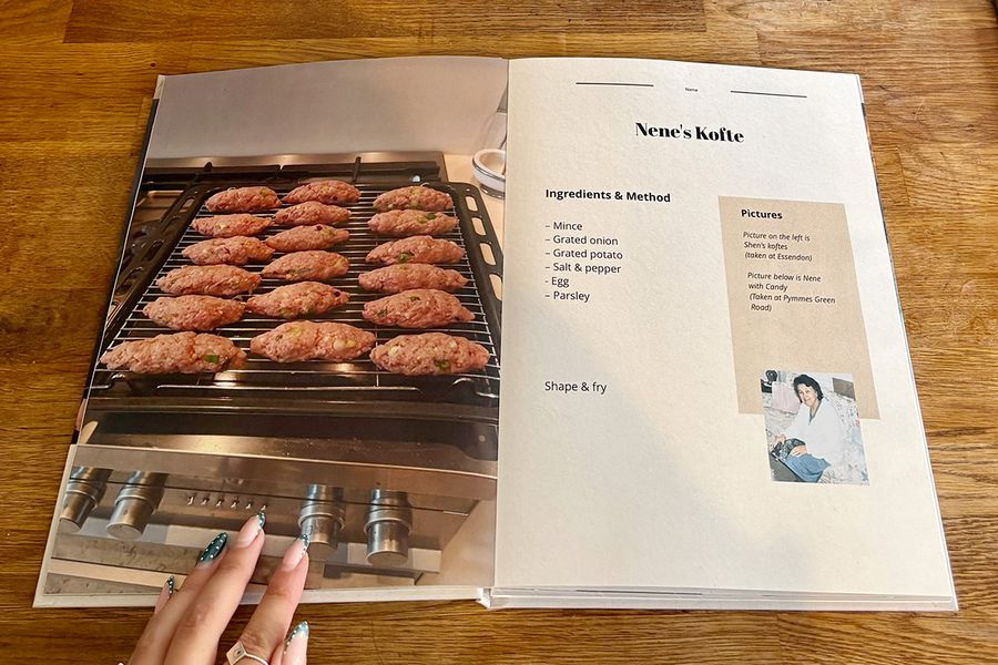 Et åpent oppslag fra Sarahs oppskriftsbok viser Nenes kofte-oppskrift, med en manikyrert kvinnehånd hvilende på boken på en trebenk, som illustrerer fotoknudsen sine siste sjekkliste-tips før man skriver ut en personlig kokebok.