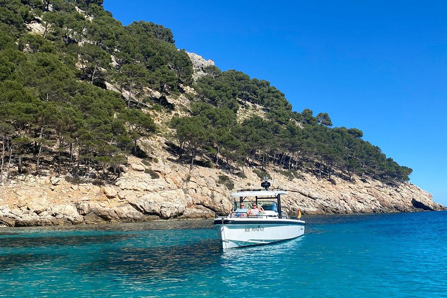 Et par sitter i en båt ved en vakker, ru kystlinje på Ibiza, som fanger den rolige og avslappede siden av en septemberferie på øya.