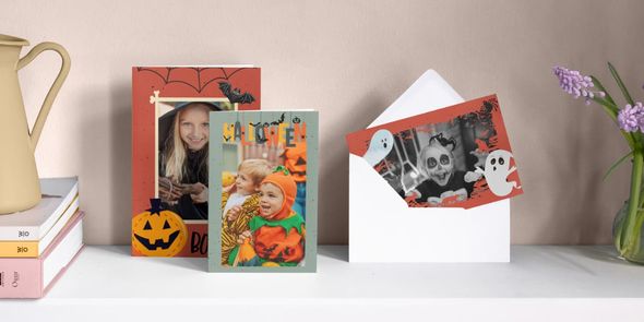 Tre personlige Halloween-kort står side ved side på en pipekant, med en liten jente utkledd som heks, en liten gutt utkledd som gresskar, og en liten jente utkledd som spøkelse omgitt av spøkelsesillustrasjoner, som introduserer fotoknudsen sin guide til å lage knallgode Halloween-invitasjoner.