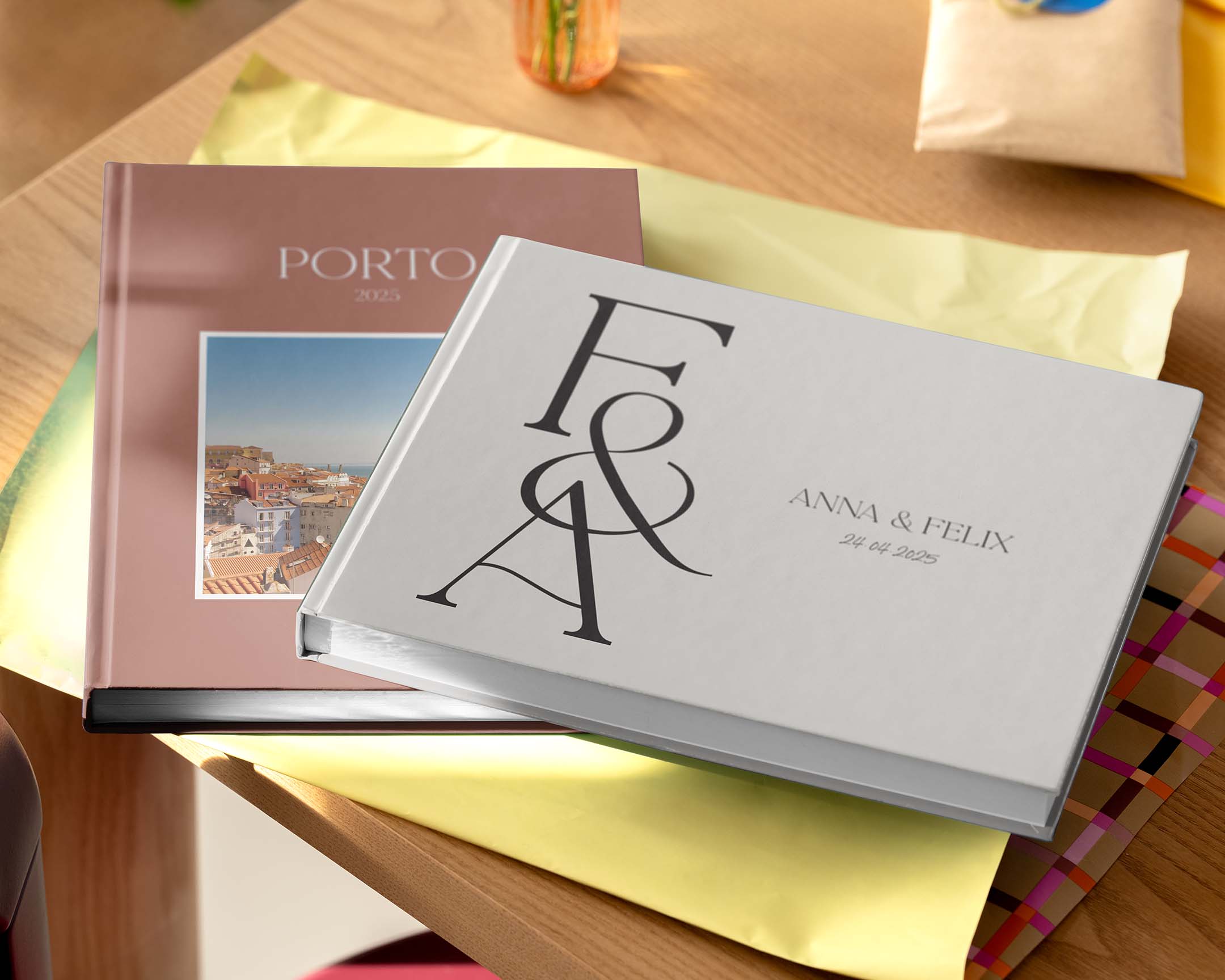 To personlige fotobøker som vises på et bord i forskjellige størrelser og design.