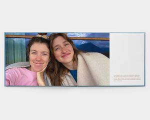En fotobok i åpen landskapsformat med bilde av to smilende kvinner