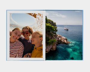 En stor portrettfotobok med bilde av en person som ser på en fjellinnsjø
