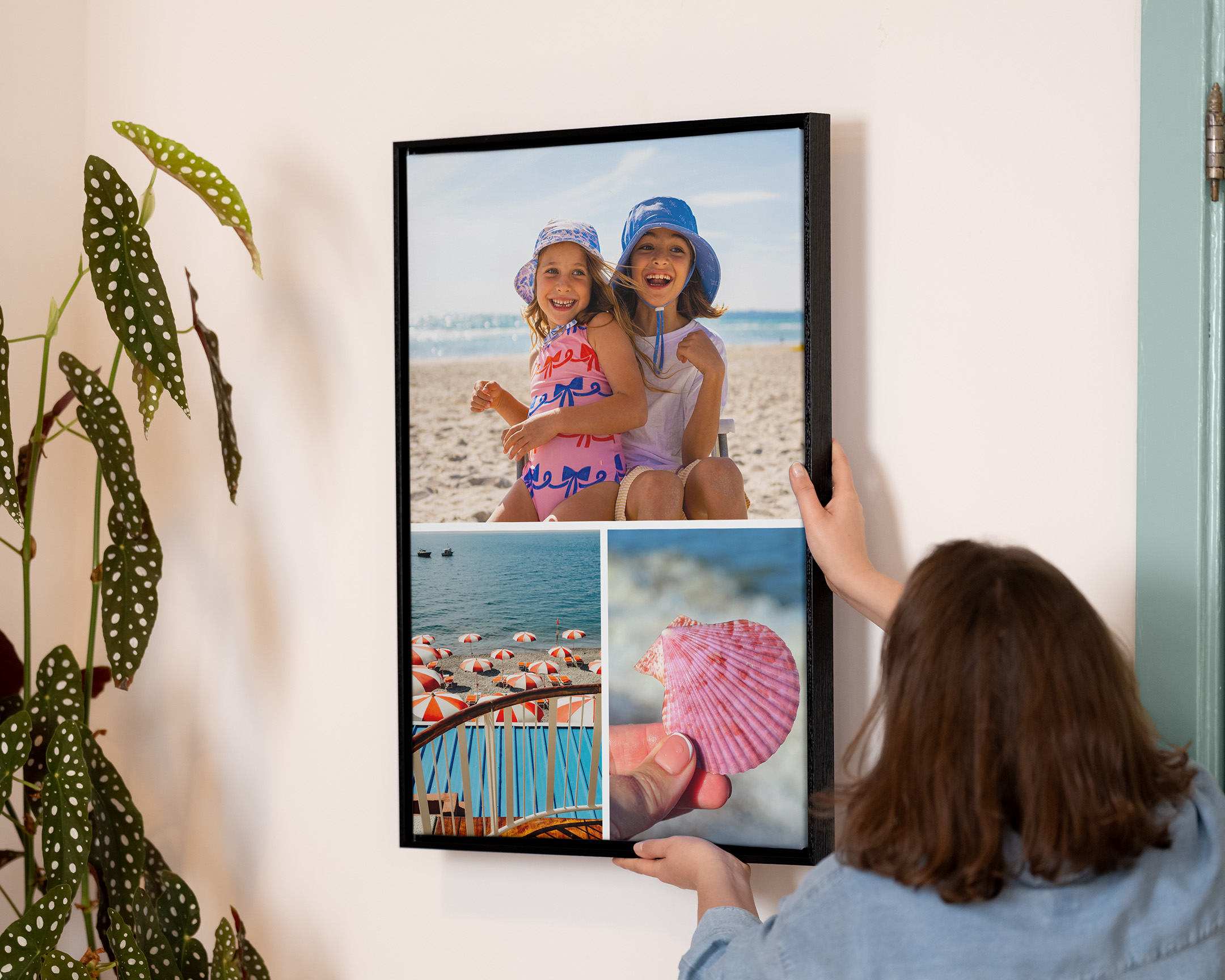 Person som henger opp en innrammet trykt collage