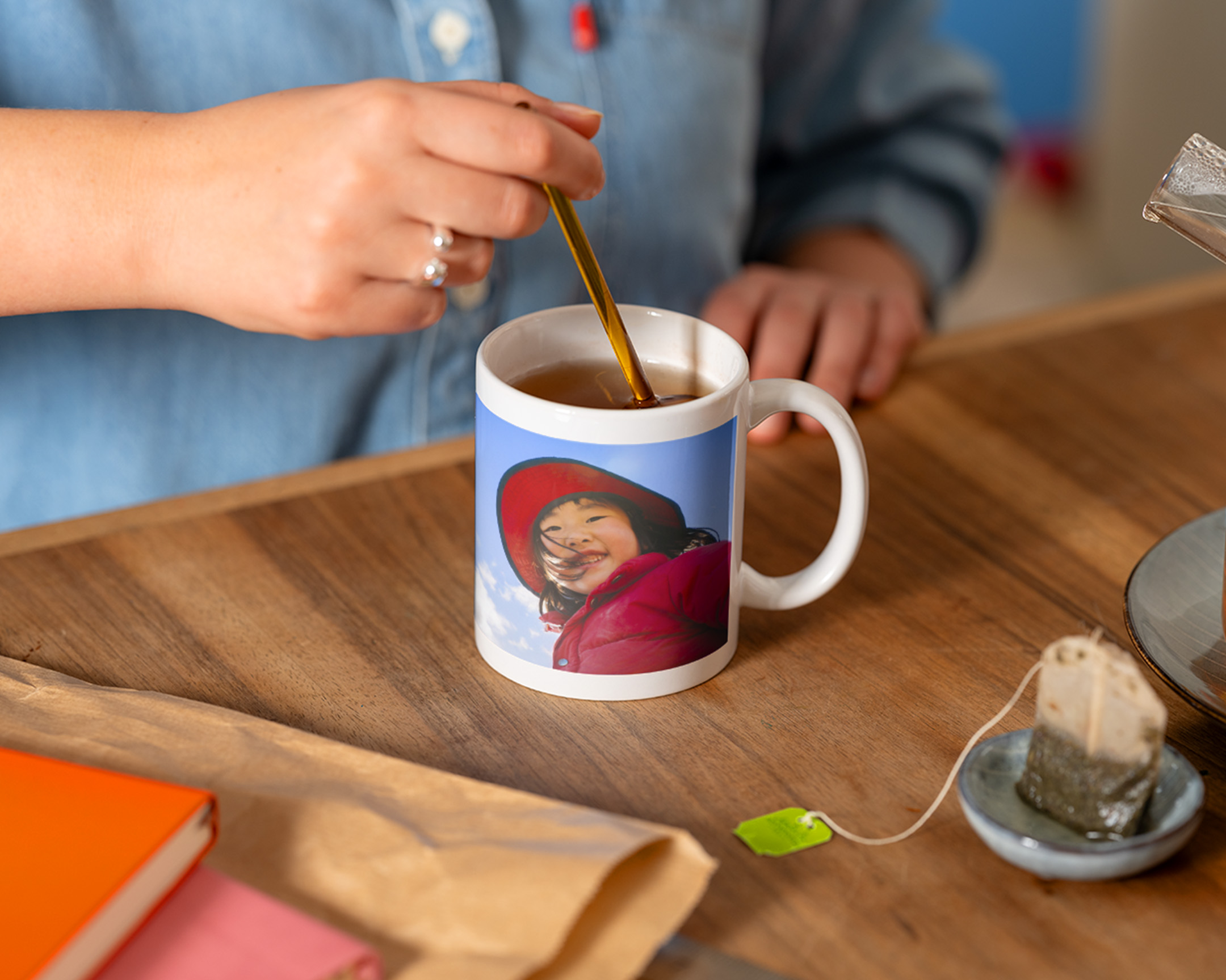 Person som rører te i en kopp med bilde