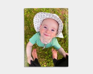 Fotoplakat med trykk av en smilende baby utendørs.